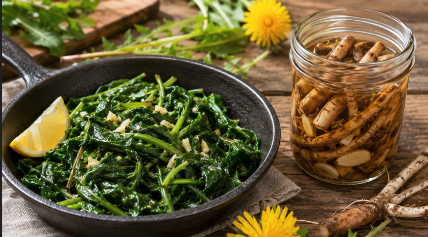Garlic-butter dandelion greens beside a jar of whole pickled dandelion roots on a rustic wooden table.